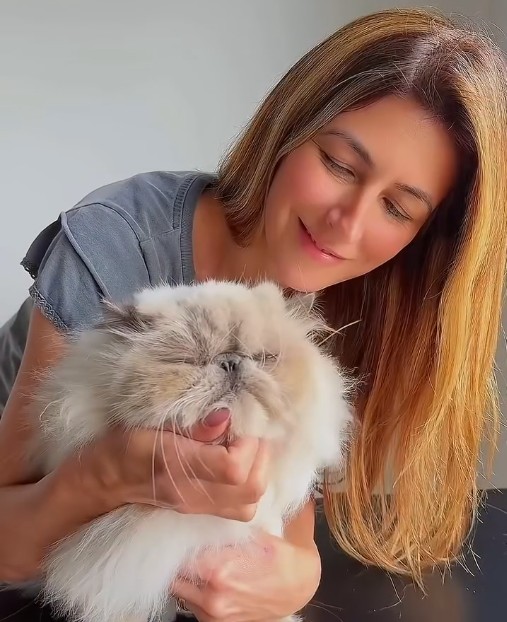 A StarGen client holding one of her cats, whose fur became her diamond